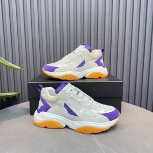 AMIRI Trainer replica sneaker in white, purple, and orange, displayed on a black box with a modern backdrop.
