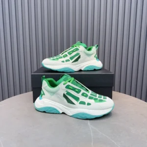 Amiri Trainer sneakers in green and white, displayed on a black box, showcasing a modern design and vibrant color scheme.