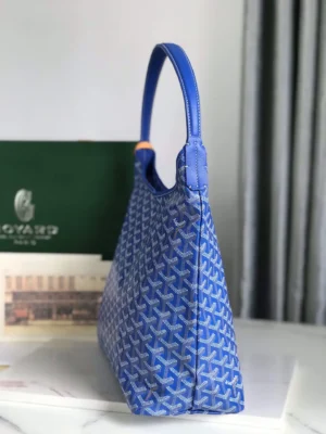 Goyard Hobo Boh è Me Stray Bag in blue, showcasing distinctive patterned design and comfortable shoulder strap, displayed against a green background.