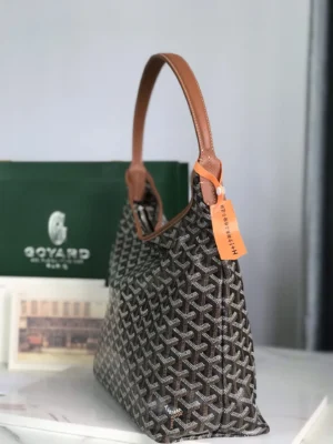 Goyard Hobo Boh è Me Stray Bag with brown leather strap, featuring a woven design, displayed beside a green Goyard box, emphasizing luxury and casual style.