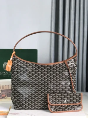 Goyard Hobo Boh è Me Stray Bag featuring a unique pattern and brown leather trim, accompanied by a matching pouch, set against a soft backdrop.