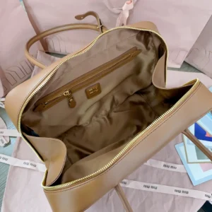 Elegant Miu Miu bowling handbag interior featuring smooth leather, cotton satin lining, and zippered pocket, on a stylish background.