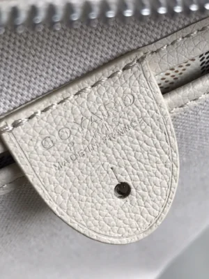 Goyard logo on a white leather tag attached to a luxury tote bag, showcasing craftsmanship and branding details.