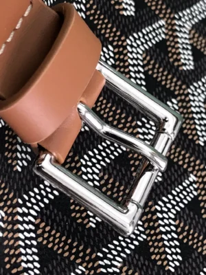 Hermes belt tan leather silver metal buckle accessory close-up on patterned fabric background