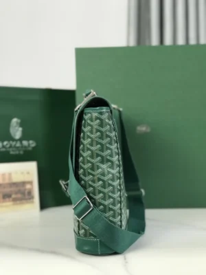 Goyard Citadin Mailman Bag in green, featuring signature pattern and detachable shoulder strap, displayed on a marble surface with branded packaging in the background.