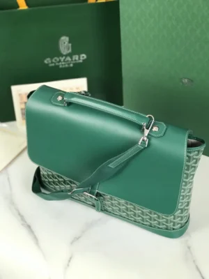 Goyard Citadin Mailman Bag in green leather and canvas, featuring a detachable shoulder strap, displayed on a marble surface with Goyard packaging in the background.