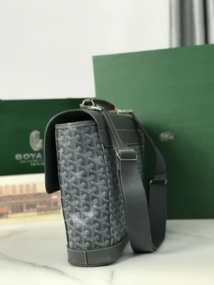 Goyard Citadin Mailman Bag showcasing luxury materials, gray canvas with signature pattern, detachable shoulder strap, and elegant design, positioned beside branded packaging.