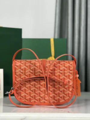 Goyard Belvedere II Bag in orange with intricate pattern, featuring adjustable shoulder straps and matching silk ribbon gift packaging in the background.