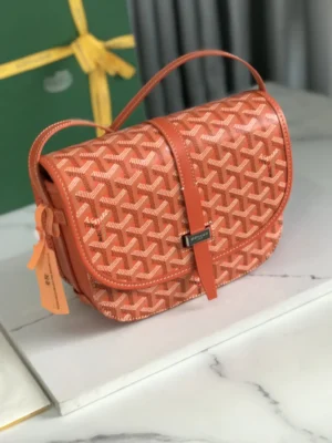 Goyard Belvedere II Bag in orange with a geometric pattern, featuring a single narrow buckle, matching silk ribbon gift packaging in the background, showcasing luxury design and practicality.