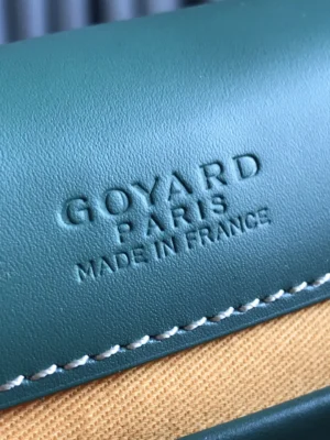 Goyard Paris logo embossed on green leather of the Belv é d è re 2 crossbody bag, showcasing luxury craftsmanship and design.