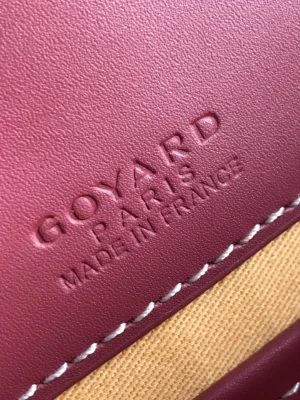 Goyard leather product close-up maroon color with embossed logo and white stitching detail
