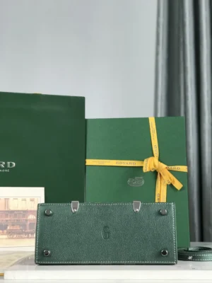 Goyard Saigon 23 green leather bag with silver metal feet and detachable strap displayed with branded packaging and yellow ribbon