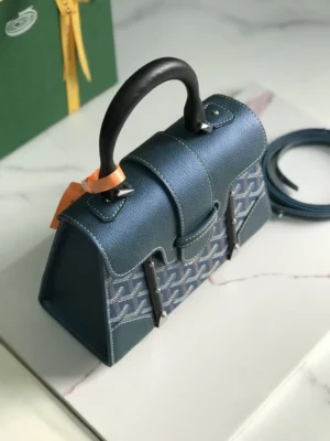 Pearl Green Goyard Sa ï gon mini bag with original packaging, showcasing structured design, detachable leather shoulder strap, and elegant craftsmanship.