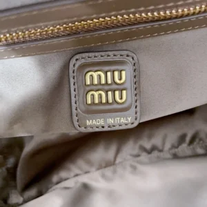 MIU MIU logo tag on a smooth fabric lining, highlighting luxury craftsmanship and Italian origin.