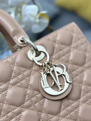Dior Book Tote Bag close-up featuring iconic "D.I.O.R." pendant, refined leather with classic wicker stitch, and elegant quilting details.