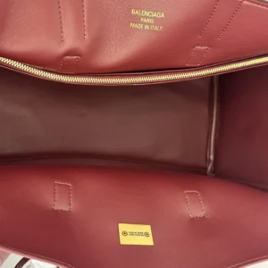 Interior view of a Balenciaga tote bag featuring gold logo print, showcasing its sleek design and spacious compartment, emphasizing the bag's luxury and practicality.