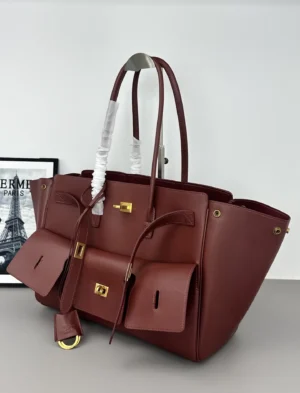 Modern City Tote Bag replica by Balenciaga, featuring a deep burgundy color, front flip decoration, square locks, and leather straps, showcasing a blend of futuristic design and practicality.