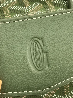 Goyard Cisalpin Backpack close-up showing embossed logo on green leather, highlighting luxury craftsmanship and design features.