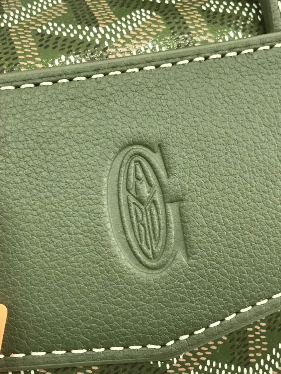 Goyard bag close-up detail green leather with signature embossed logo and white stitching