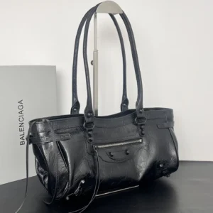 Black leather Balenciaga Le City Horizontal Motorcycle Bag with vintage hardware, displayed on a stand, emphasizing its stylish design and versatility.