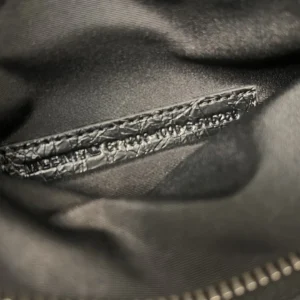 Interior view of the Balenciaga Le City Horizontal Motorcycle Bag showcasing the textured black leather tag and lining, highlighting the bag's quality and design.