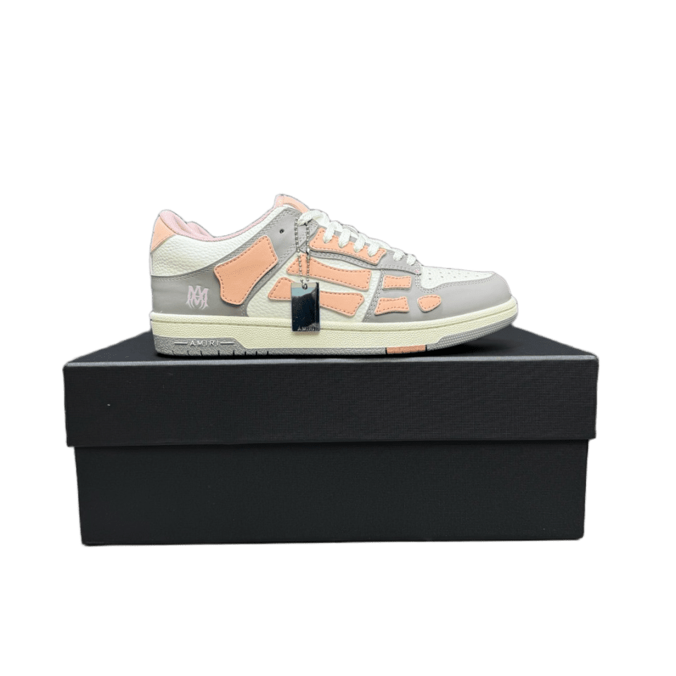 Bone AMIRI Trainer sneaker in grey and pink colorway displayed on a black box.