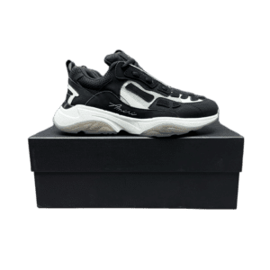 AMIRI Trainer sneaker in black and white, displayed on a black shoe box, showcasing its stylish design and luxury appeal.
