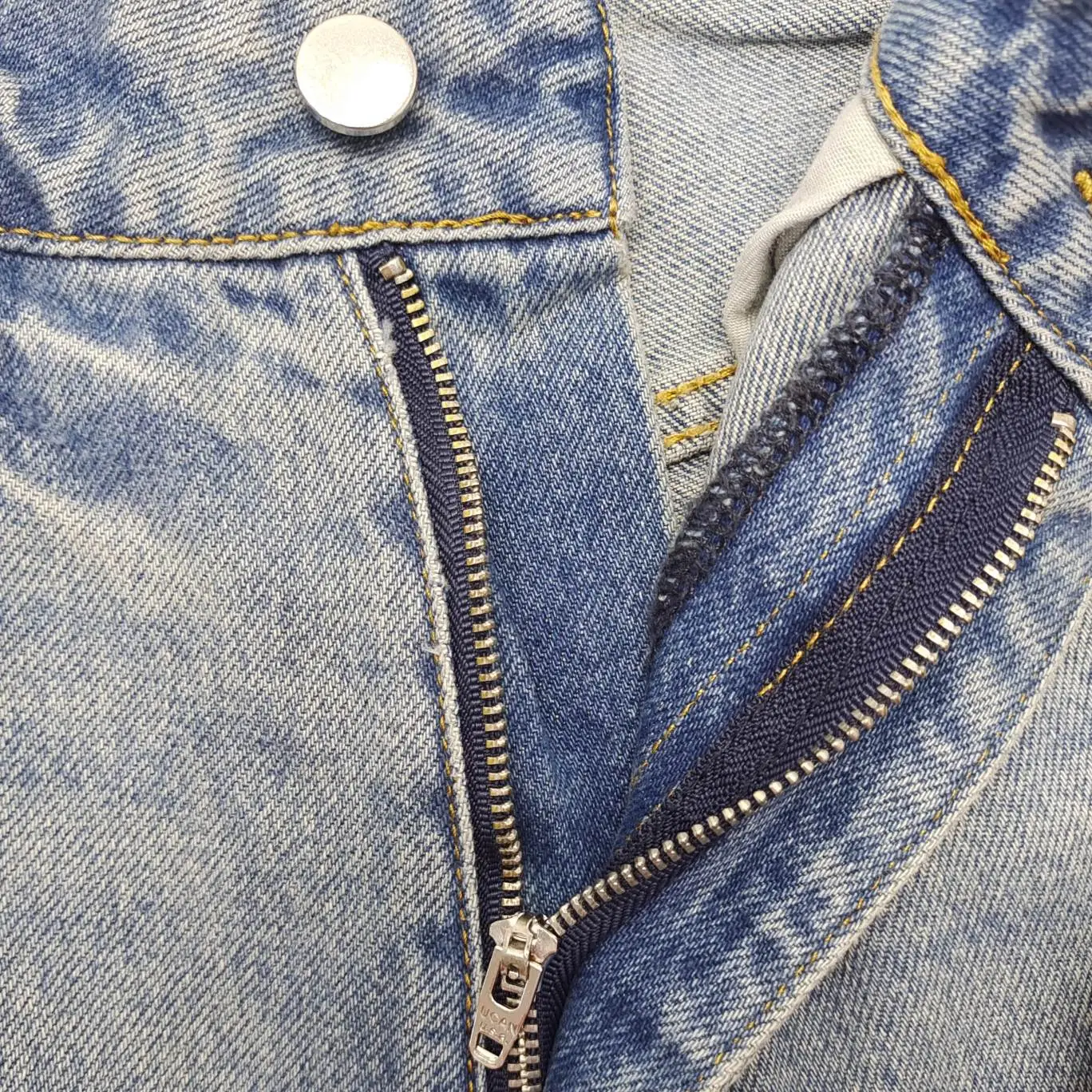 Levi's 501 original fit blue denim jeans with metal button and zipper closure close-up