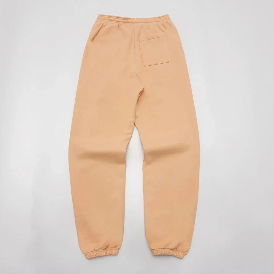 The image shows beige sweatpants laid flat with an elastic waistband and cuffed ankles. One back pocket is visible. However, it does not match any product types listed for generating SEO alt text in your rules (watches, sneakers, bags, accessories). Please specify if you want a custom alt text for this product type or provide a different product image from the categories mentioned.