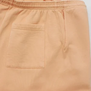 Sp5der Orange Pink Star Pants showcasing soft fabric texture, elastic waistband, and side pocket detail, emphasizing stylish design for fashion-conscious consumers.