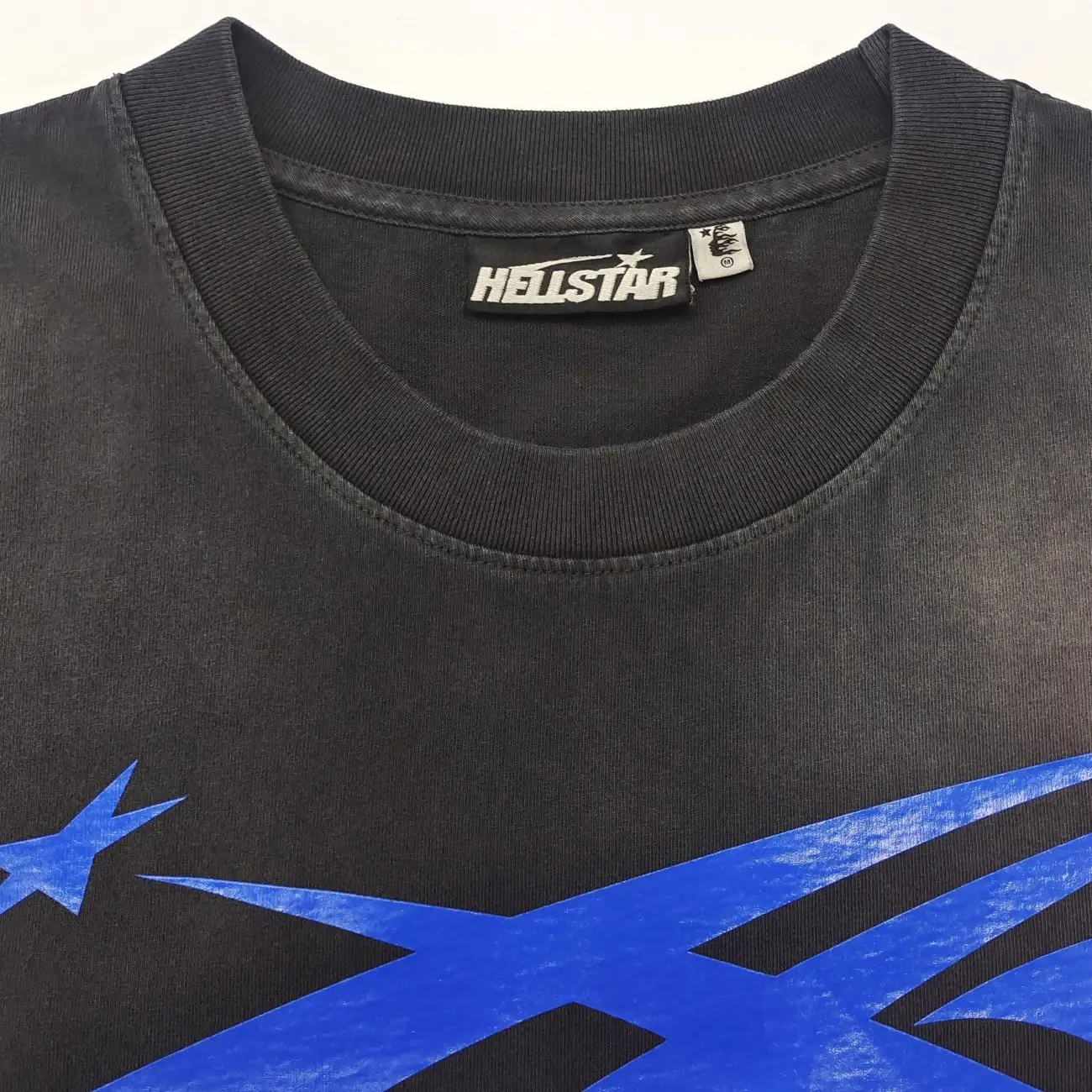 Hellstar graphic tee black color cotton material with blue star print design close-up neckline view
