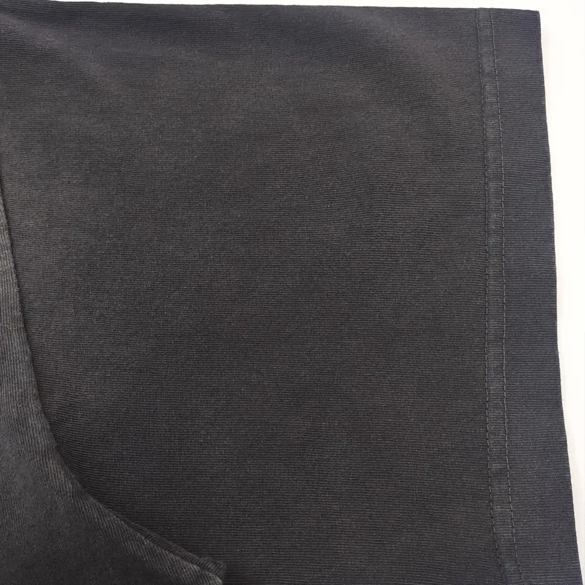 Supreme Black cotton ribbed fabric clothing material close-up with visible stitch detail