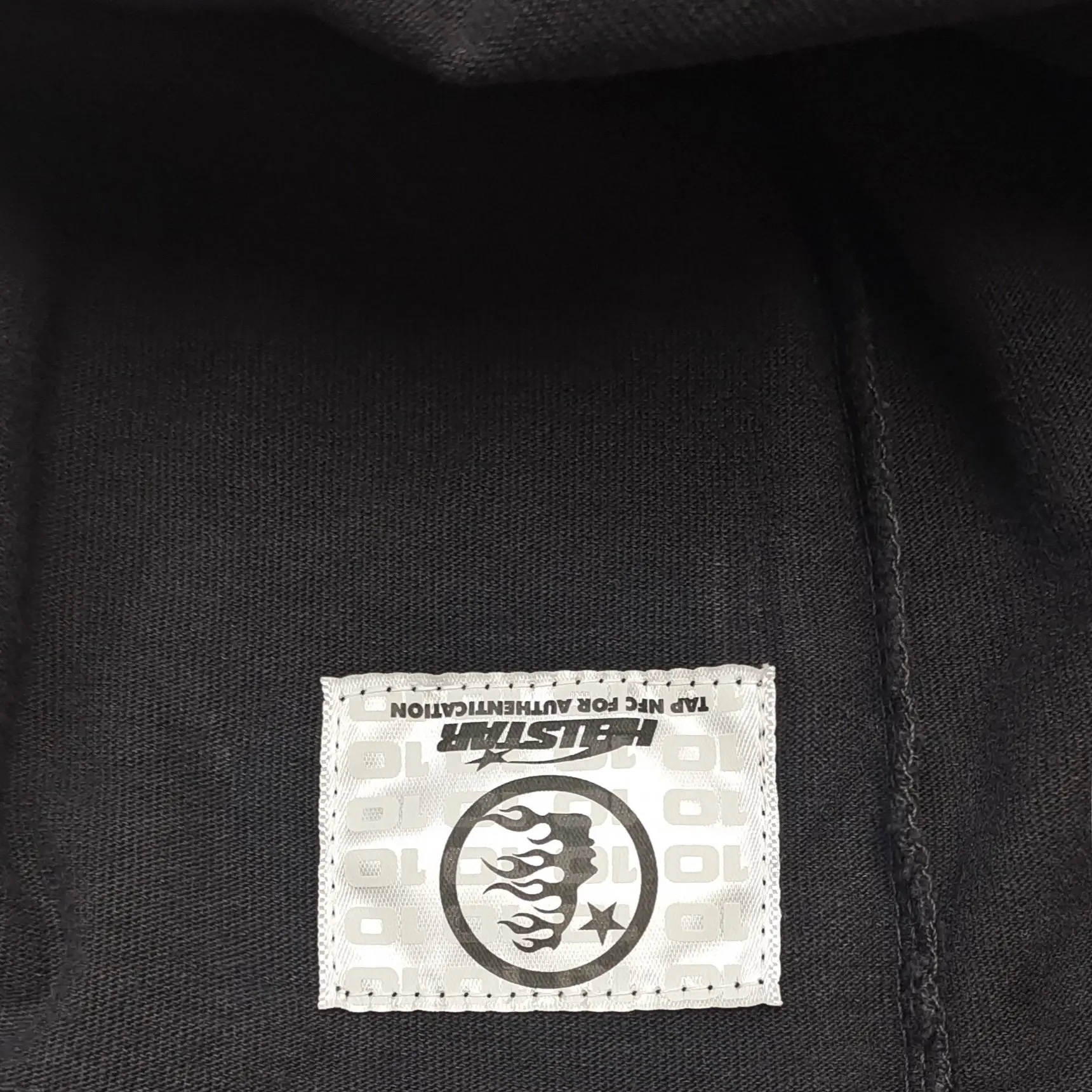 Hellstar clothing tag black fabric with white stitched logo patch featuring flames and star design