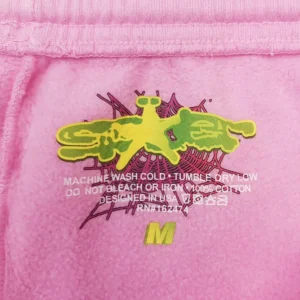 No brand or product type visible, pink cotton fabric with yellow and green graphic and size M label