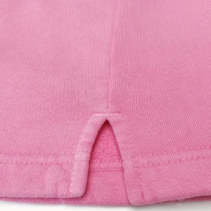 Unknown brand pink knit fabric garment made from soft cotton blend with ribbed texture and hem slit detail