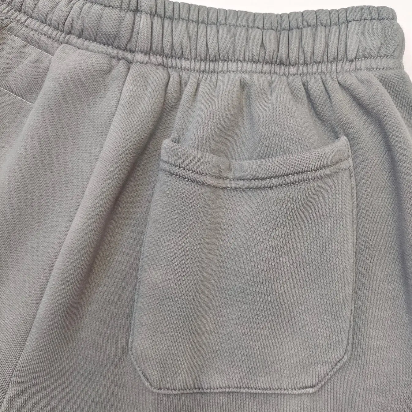 No visible brand or model information for gray cotton sweatpants with an elastic waistband and back pocket