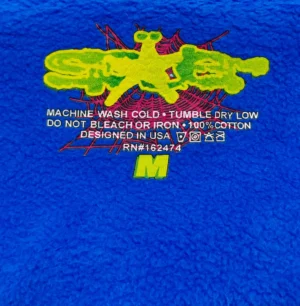 Supreme fleece jacket medium blue cotton with yellow graphic and care instructions printed inside collar