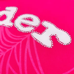 Close-up of the SDER logo in white rhinestones on a vibrant pink hoodie fabric, showcasing luxury replica apparel design.