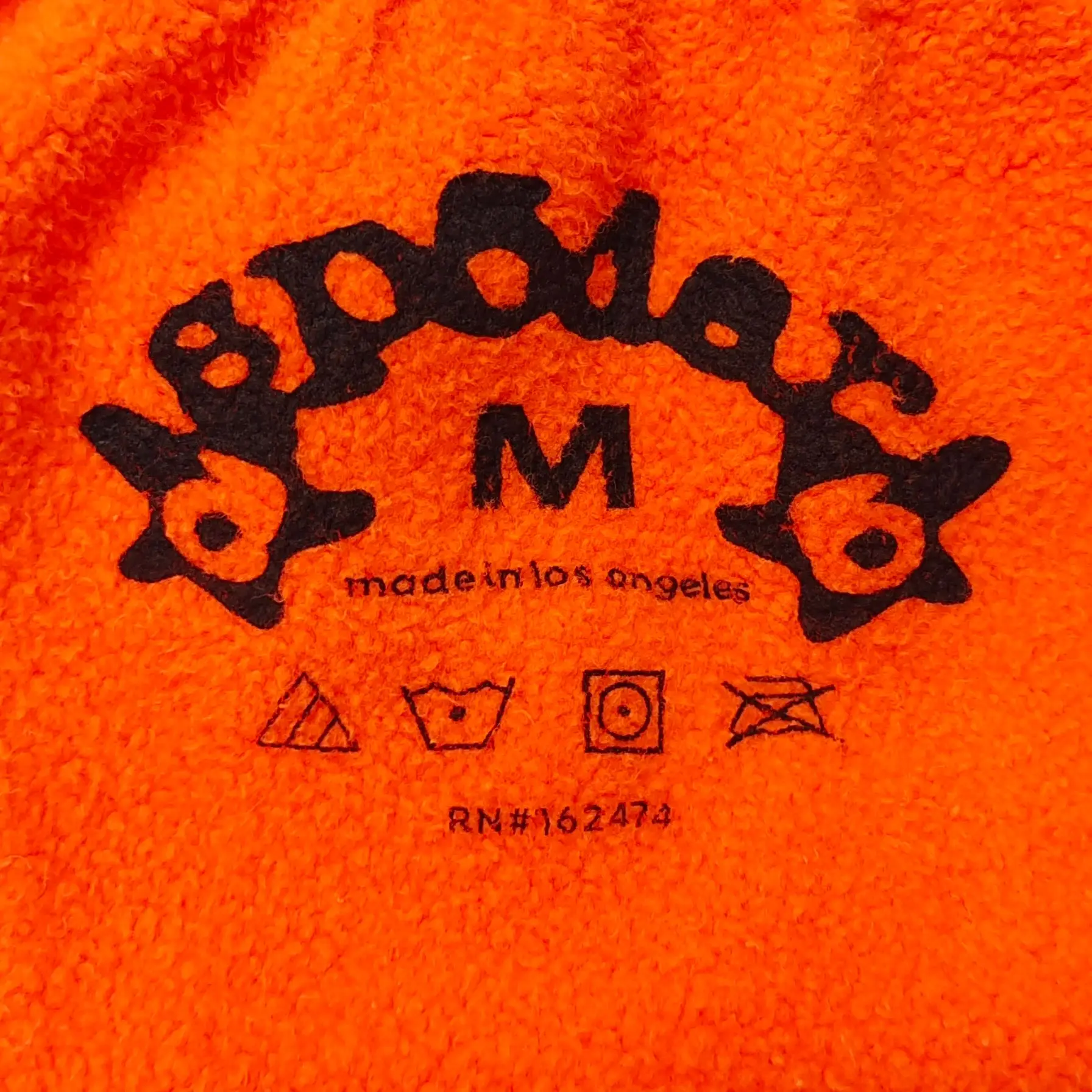 Bape hoodie medium size bright orange fleece fabric with black logo and care symbols printed inside