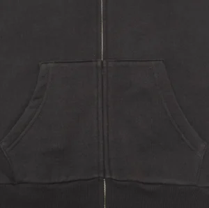 No brand or model visible, black zip-up hoodie made of cotton fabric with front pocket detail