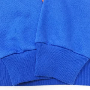 The image shows a close-up of a blue fabric with ribbed cuffs, likely part of a sweater or sweatshirt. Since the user asked for alt text for products from repsgoat.com with SEO optimization and a specific format based on product type (watches, sneakers, bags, accessories), and none of these categories or brand is visible in the image, it is unclear what brand or product it is. If this is a product image for repsgoat.com with blue cotton knit fabric sleeves, here is an SEO optimized suggestion for a sweatshirt or sweater if a brand/model was known (but since it's not provided, I cannot include brand/model). Please confirm product type and brand/model to create the correct alt text, or if you want me to only describe the visible features in general.