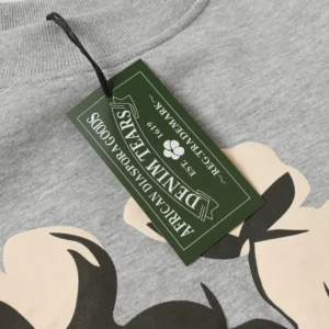 Denim Tears hoodie tag featuring brand name, logo, and "Africa Diaspora Goods" label on a grey fabric background.