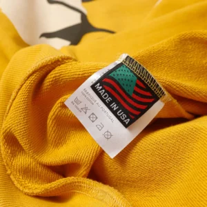 No brand visible yellow cotton garment tag showing made in USA and care instructions