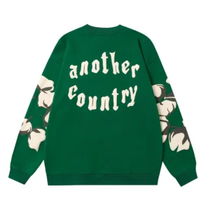 Green hoodie featuring "another country" text and floral design, part of the Denim Tears Cotton Flower collection, trendy apparel for European and American markets.