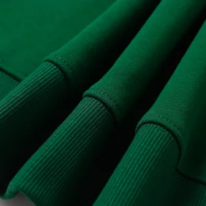 Close-up of green fabric with ribbed cuffs, highlighting the quality of the Denim Tears Cotton Flower hoodie.
