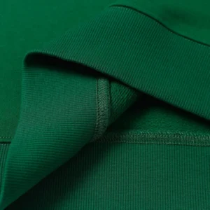 Close-up of a green hoodie showcasing the fabric texture and collar details, highlighting the high-quality material of the Denim Tears Cotton Flower hoodie.