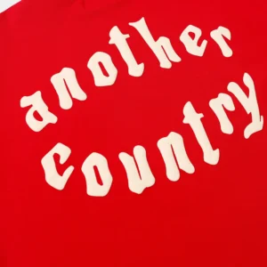 Another Country hoodie red cotton fabric with white curved text logo design