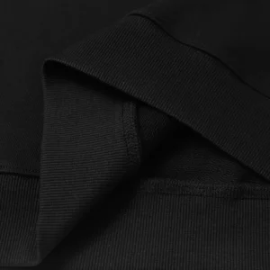 Close-up of black hoodie fabric showcasing high-quality stitching and ribbed cuffs, related to DENIM TEARS Cotton Flower trendy clothing.