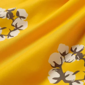 Cotton flower design on yellow fabric, featured in Denim Tears Cotton Flower shorts collection.