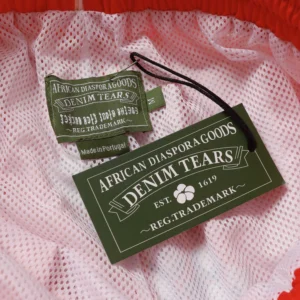African Diaspora Goods Denim Tears clothing tag green fabric label made in Portugal sewn on mesh lining